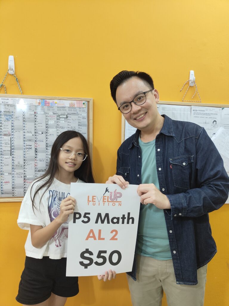 Kydon and a LevelUp Tuition student celebrating a Primary 5 Math achievement, holding a sign that rewards AL2 students with $50.
