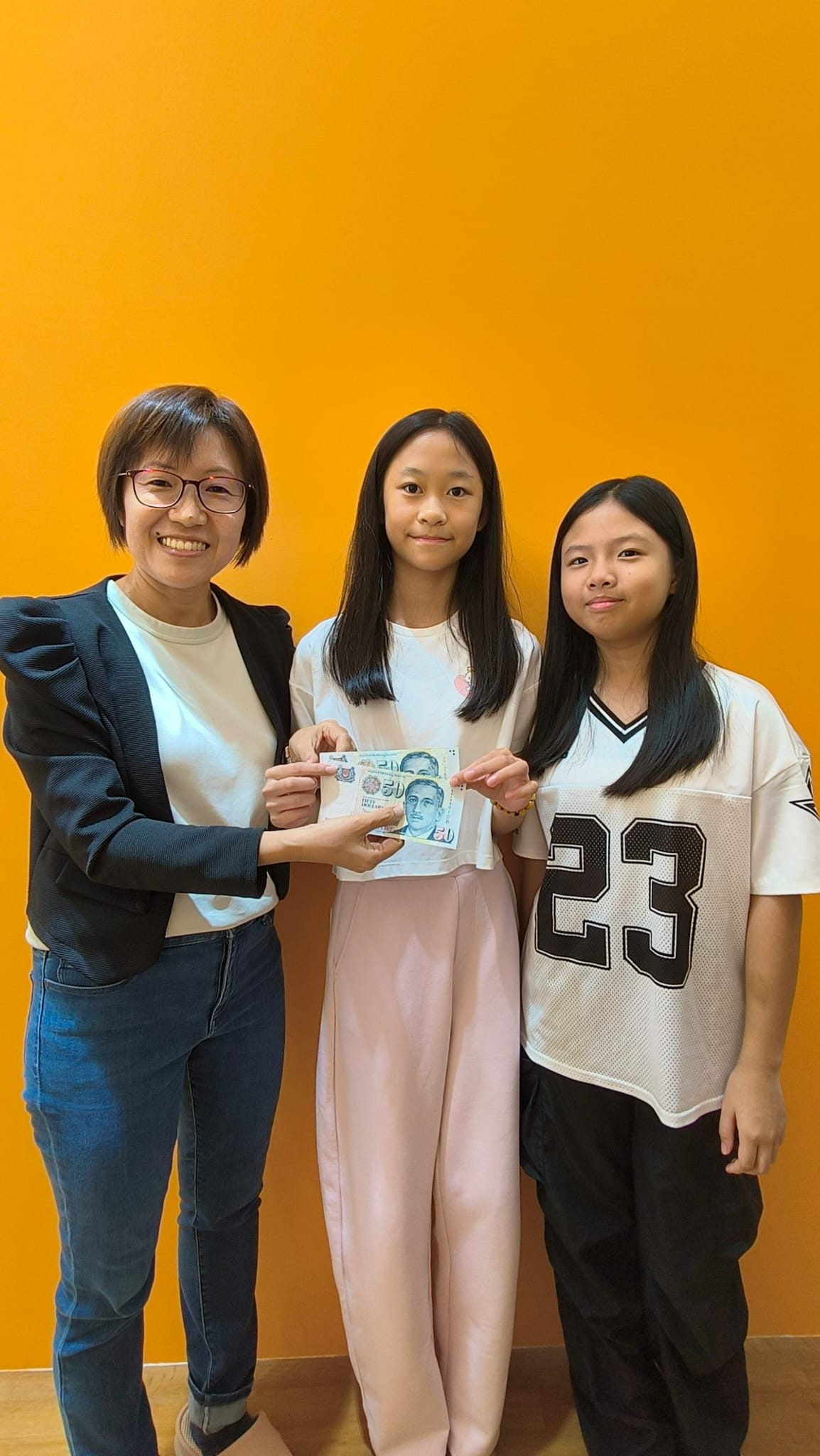 Chloe and her friend Clara receiving a reward from their teacher at LevelUp Tuition